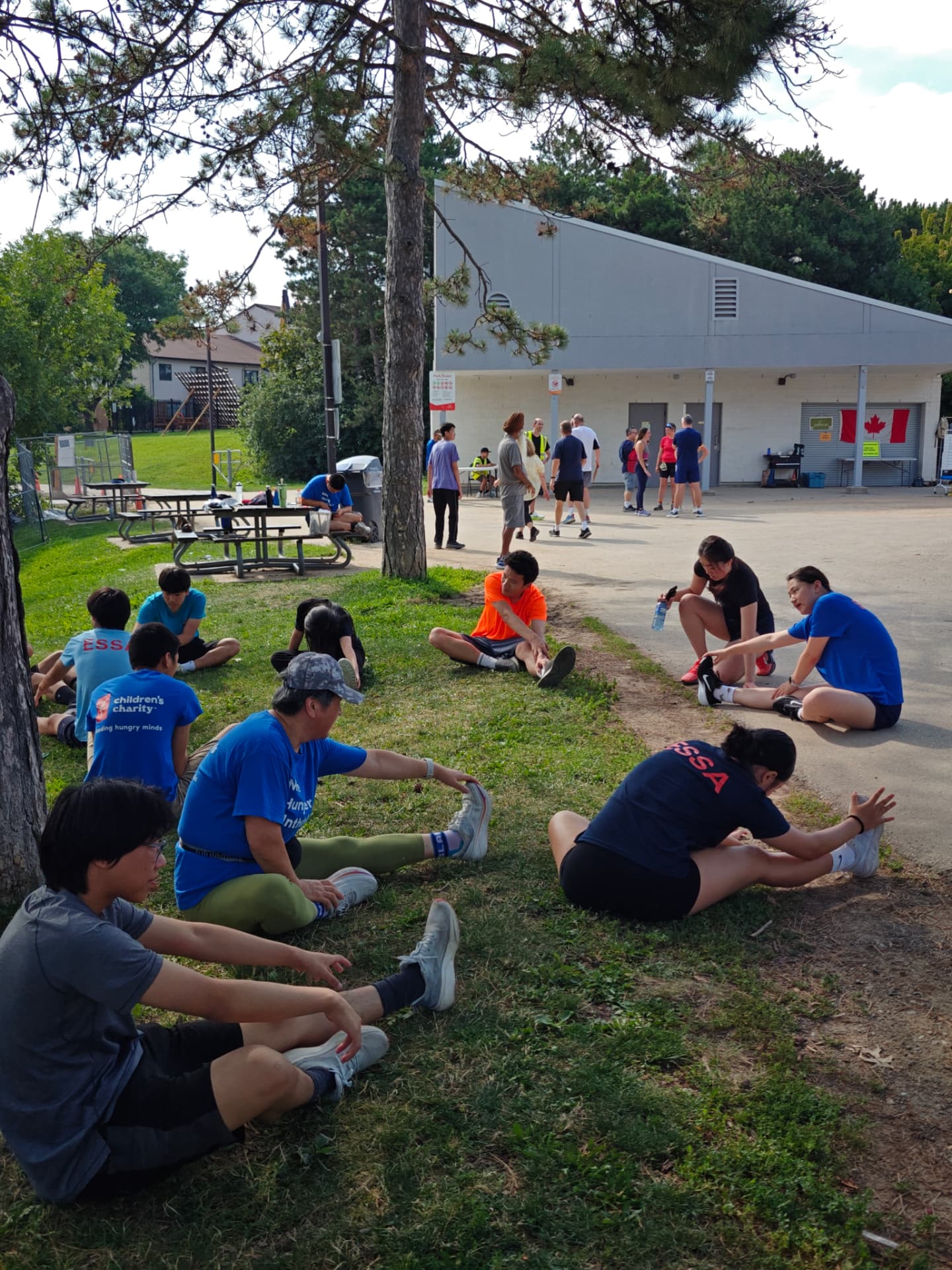 Athletes and volunteers stretching on the grass after the parkrun